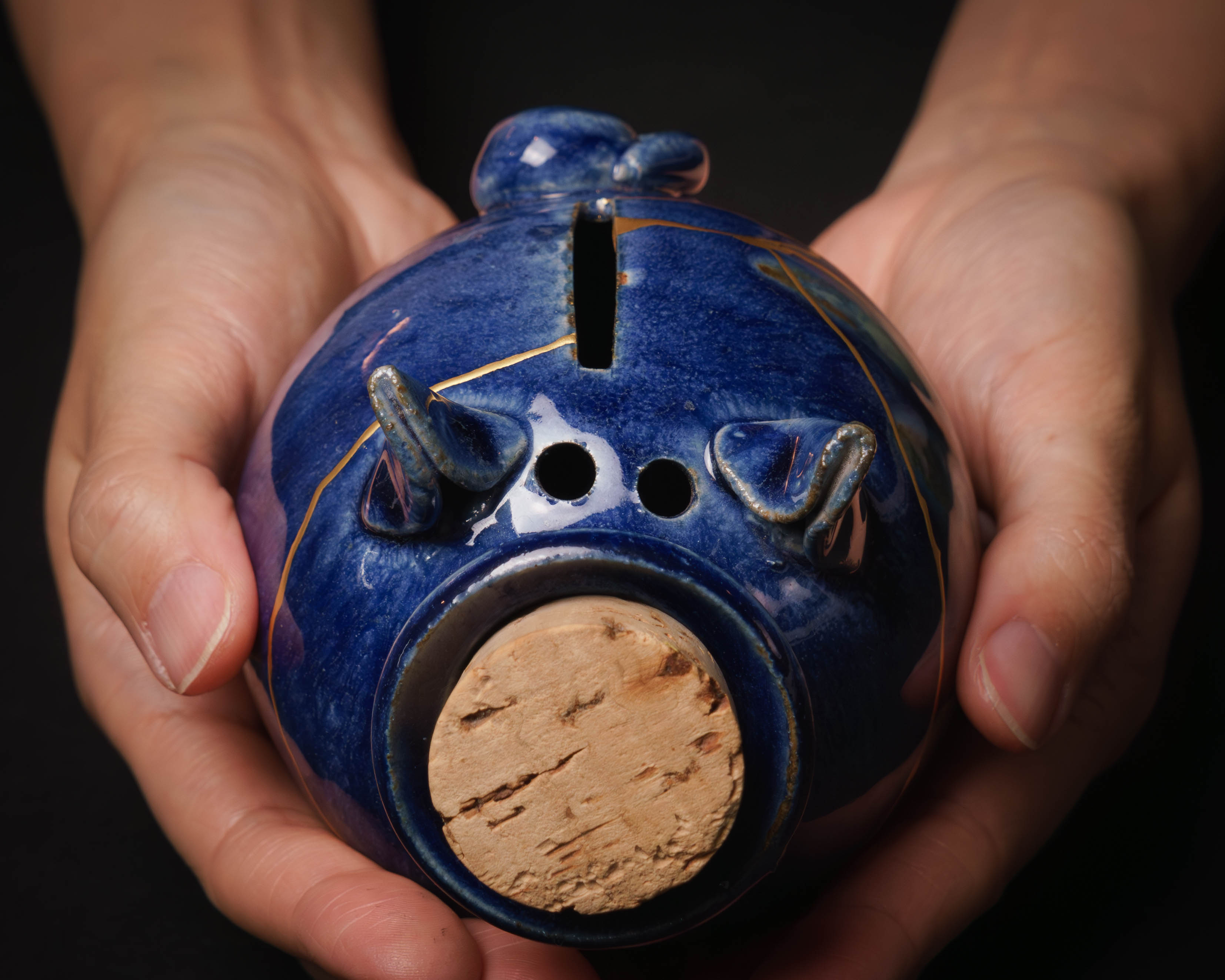 kintsugi repaired piggy bank in hands